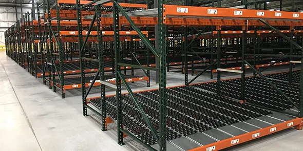 Empty warehouse with green and orange pallet racks ready for storage